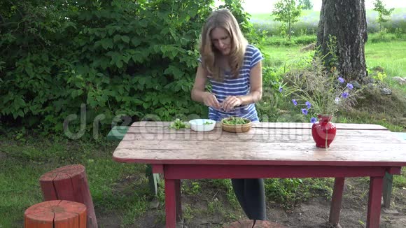 素食农民女孩把鲜绿的豌豆壳放在红色的木桌上4K视频的预览图