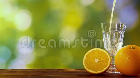 在天然叶子的背景下在花园里倒入杯中的橙汁视频的预览图
