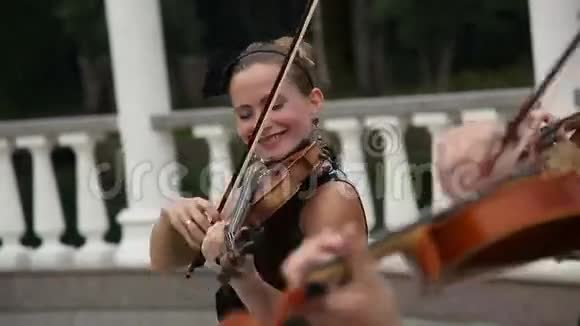 一群女小提琴手在街上演奏旋律视频的预览图