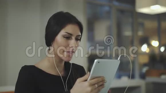 办公室里一个女人拿着平板电脑微笑着说话视频的预览图