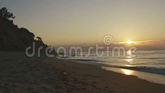 在寂静的夕阳下海浪悄悄地在沙滩上翻滚海洋平静概念视频的预览图