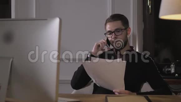 聪明快乐的年轻商人用手机在办公室看文件视频的预览图