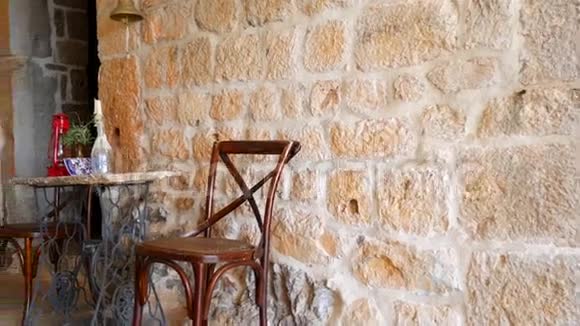 老式椅子和桌子在石墙的背景下视频的预览图