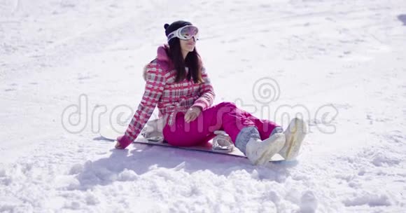 快乐的年轻女子坐在滑雪板上视频的预览图