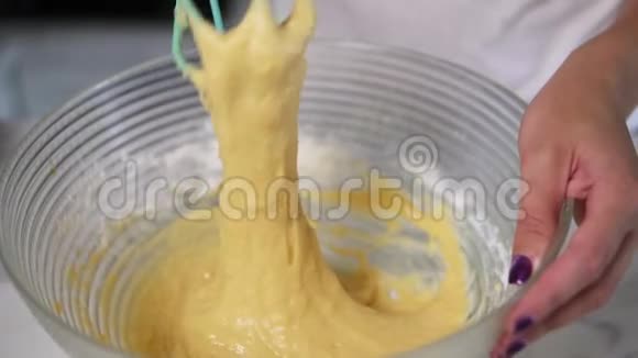 在厨房里用搅拌器制作面团混合配料的女性手的特写镜头自制食物慢动作视频的预览图