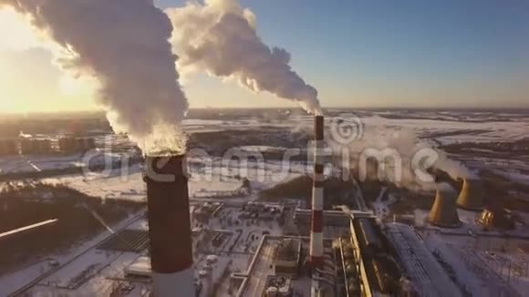 冬季日落背景下吸烟烟囱电站空中景观视频的预览图