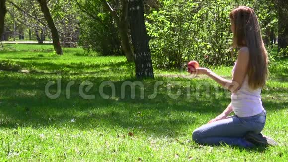 女人把苹果给公园里的小女孩视频的预览图