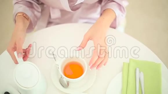 穿着浴袍喝茶喝茶的女人视频的预览图
