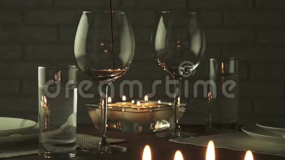 在烛光下盛满红酒的酒杯浪漫的晚间慢动作股票录像视频的预览图