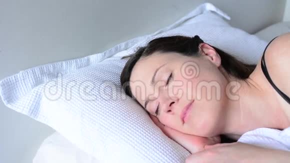 一个年轻的女人在床上醒来在床上快乐视频的预览图
