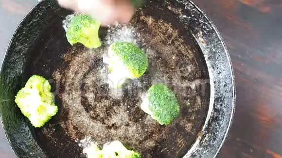 用豆子和玉米在铸铁锅中烤西兰花慢动作视频的预览图