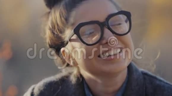 时尚外套和眼镜的城市模特女人有乐趣魅力少女Autumm街道的时髦发型视频的预览图