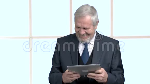 穿着商用电脑平板电脑西装的老人视频的预览图