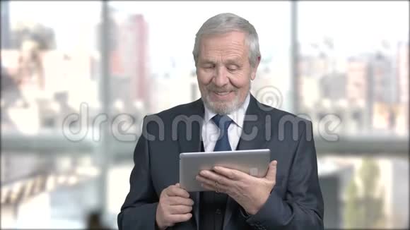 快乐的高级商人与个人电脑平板电脑视频的预览图