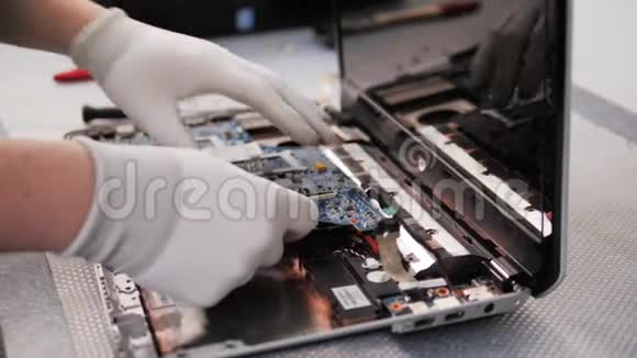 用毛刷修复PC处理器对笔记本电脑电路板进行拆卸和清洗的男性手部特写镜头视频的预览图
