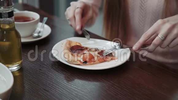 一只雌性手切吃一片披萨特写镜头在咖啡馆里交流和朋友视频的预览图