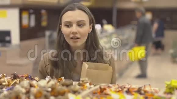 漂亮的女孩在超市挑选糖果视频的预览图