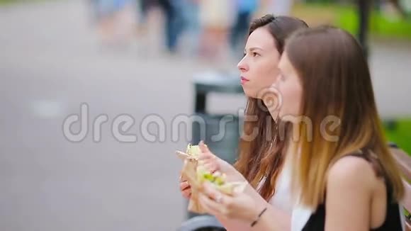 高加索女人在户外的街上吃汉堡包快餐三明治饥饿的活跃女孩和吃街头食品的女孩视频的预览图