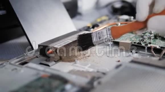 用毛刷修复PC处理器对笔记本电脑电路板进行拆卸和清洗的男性手部特写镜头视频的预览图