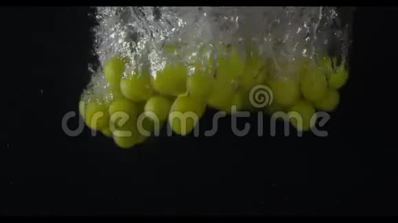一串绿色的葡萄在镜头中央潜入水中黑色背景慢动作米秒视频的预览图