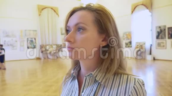 俄罗斯索契2018年9月28日索契市美术馆社论一个优雅美丽的女人看着视频的预览图