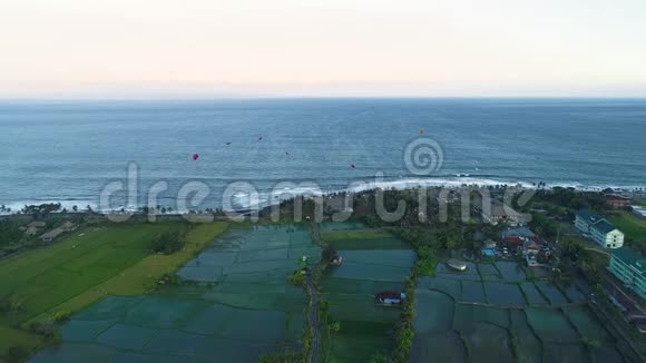 晚上风筝在靠近水稻梯田的海滨飞翔视频的预览图