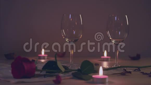 在酒杯里斟红酒用玫瑰蜡烛的浪漫场景慢动作视频的预览图