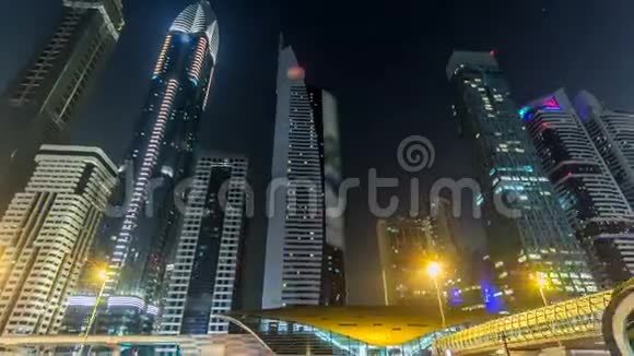 迪拜市中心塔楼夜间延时超移谢赫扎耶德的道路与高大的摩天大楼视频的预览图