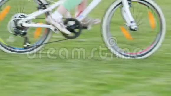 夏日阳光明媚快乐的小女孩骑着自行车在草地上视频的预览图