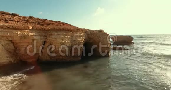 在无人驾驶飞机上绕着被海浪冲刷过的石砌视频的预览图