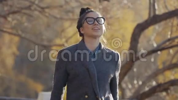 美丽的黑发年轻女子在外面的街道上玩得开心和微笑学生女孩放学后散步视频的预览图