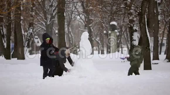 幸福的家庭在雪地上堆雪人视频的预览图