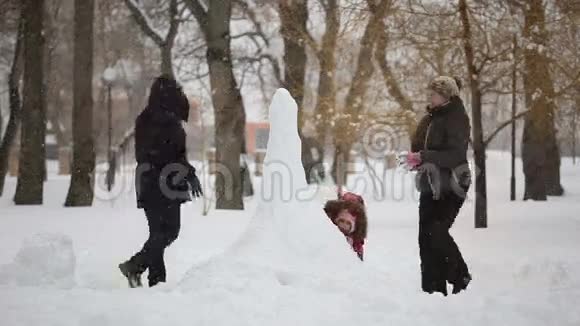 幸福的家庭在雪地上堆雪人视频的预览图