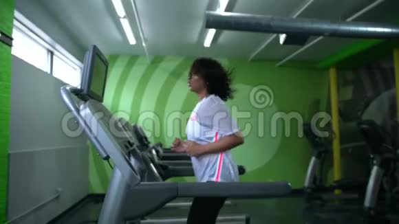 在健身房跑步机上工作的非裔美国妇女视频的预览图