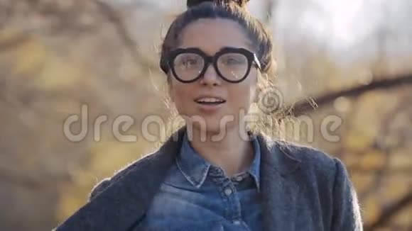 时尚外套和眼镜的城市模特女人有乐趣魅力少女Autumm街道的时髦发型视频的预览图