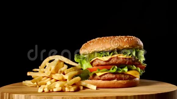 手工牛肉汉堡和炸薯条黑色背景的酱汁快餐食品视频的预览图
