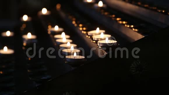在暮色中在寺庙里点燃蜡烛燃烧教堂蜡烛视频的预览图