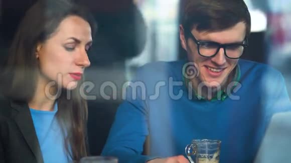 美丽的年轻女人和男人在咖啡馆里谈判视频的预览图