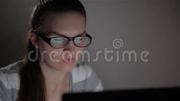 年轻女子晚上用笔记本电脑美丽的女学生晚上学习视频的预览图