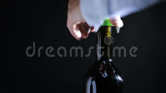 手人用开瓶器打开一瓶酒黑色背景视频的预览图