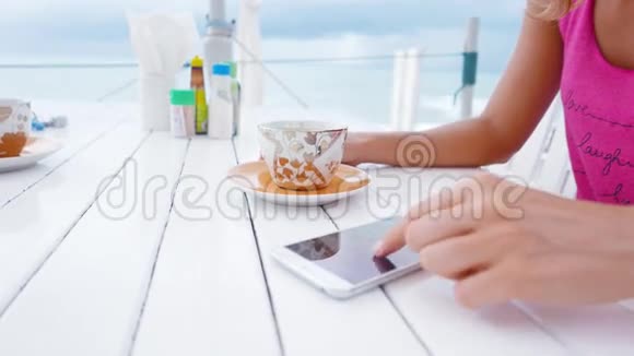 年轻女性使用白色智能手机喝酒视频的预览图