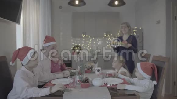 可爱的兴奋的快乐的六个家庭在节日气氛中庆祝圣诞晚餐舒适的厨房视频的预览图