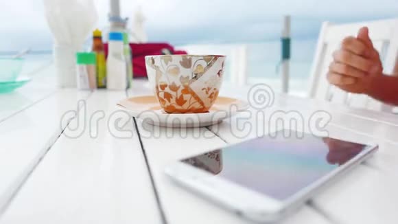 年轻女性使用白色智能手机喝酒视频的预览图
