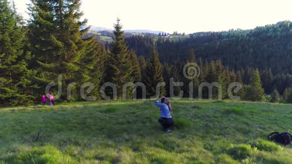 摄影师女人在森林里散步春天视频的预览图