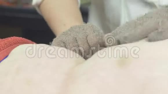 按摩师用按摩手套给美容院的妇女按摩肥胃视频的预览图