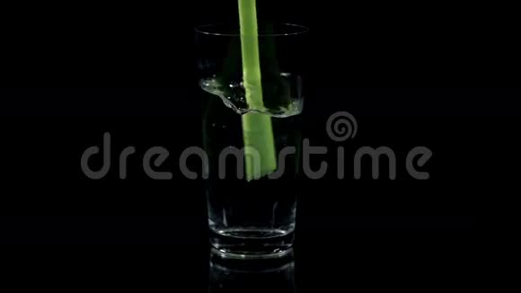 在黑色背景下用绿色吸管搅拌饮料视频的预览图