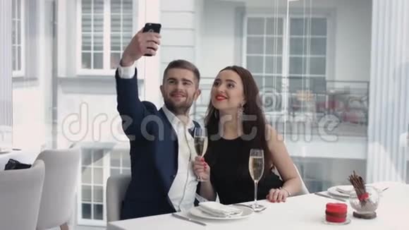 一对快乐的情侣在餐厅用智能手机自拍视频的预览图