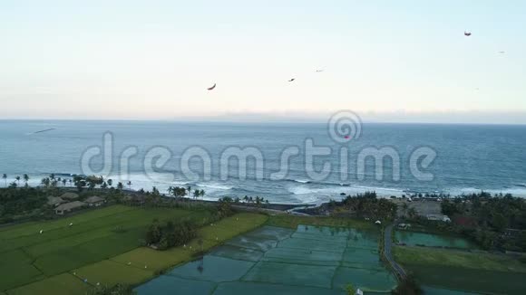 晚上风筝在靠近水稻梯田的海滨飞翔视频的预览图