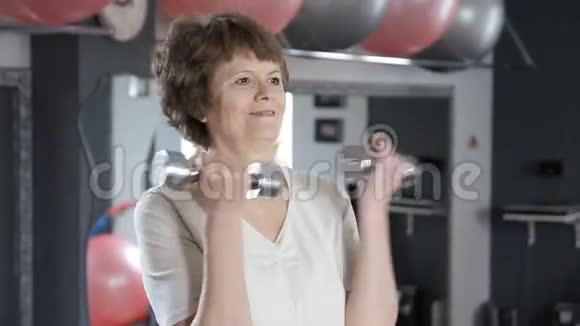 老年女性提哑铃成熟健身视频的预览图