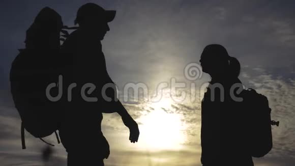 幸福的家庭游客剪影在日落拥抱接吻团队合作旅行理念带背包的男女情侣视频的预览图